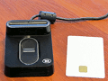 ACS AET65 Smart Card Reader with Fingerprint Sensor, side-by-side with a smart card